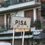 white PISA road signage near building